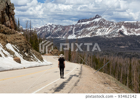Woman on Scenic Road surrounded by Mountains and Trees. Woman on Scenic Road surrounded by Mountains and Trees. 93462142