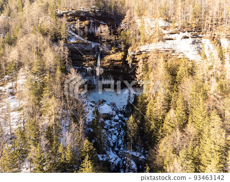 Aerial view of Pericnik slap or Pericnik Waterfall in winter time, Triglav National Park, Slovenia. Upper and lower waterfalls cascading over a rocky cliff, reachable by a picturesque walking trail. 93463142