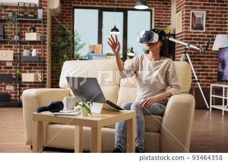 Happy asian woman enjoying wearing VR virtual reality headset, modern glasses technology headset future device gadget digital entertainment game simulation 93464358