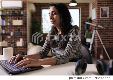 Indian woman working on laptop website, analyzing online report and browsing internet network from home. Dong remote work on wireless computer to send email and do research plan, webinar study. 93464366