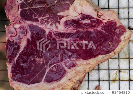 Close up of Fresh cut, raw T-bone steak prepared for cooking on the grill Close up of Fresh cut, raw T-bone steak prepared for cooking on the grill 93464810