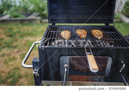 salmon steaks on grill are coking on the firewood in the backyard. salmon steaks on grill are coking on the firewood in the backyard. 93464990