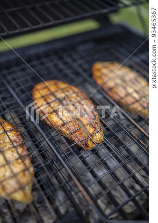 selective focus. salmon steaks on grill are coking on the firewood in the backyard. 93465367