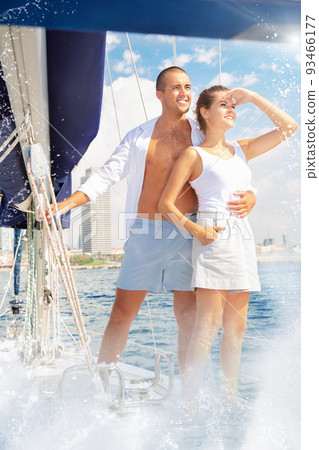 Young loving couple enjoying sea trip on pleasure sailboat along Young loving couple enjoying sea trip on pleasure sailboat along 93466177