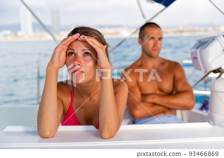 Frustrated woman with husband at sailboat Frustrated woman with husband at sailboat 93466869