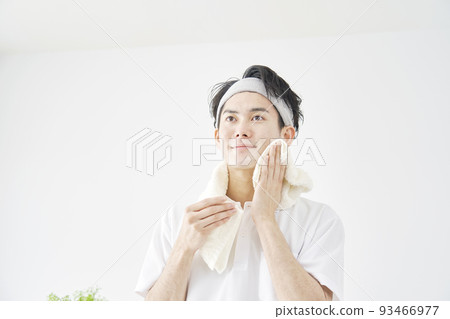 Man wiping his face with a towel at home Man wiping his face with a towel at home 93466977