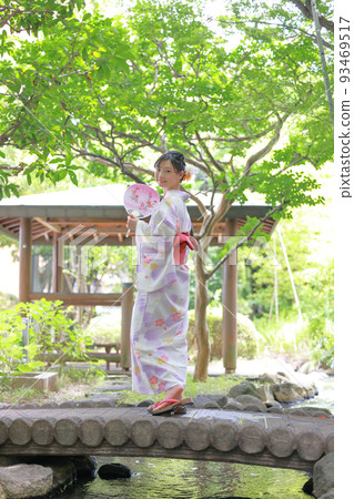 A woman in a yukata who turns around and smiles on the bridge 1 A woman in a yukata who turns around and smiles on the bridge 1 93469517