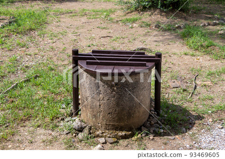 A cylindrical well with a wooden lid A cylindrical well with a wooden lid 93469605
