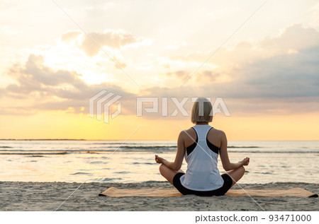 woman meditating in lotus pose on beach woman meditating in lotus pose on beach 93471000
