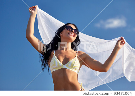 woman in bikini swimsuit with cover-up over sky woman in bikini swimsuit with cover-up over sky 93471004