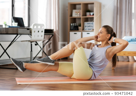 happy teenage girl exercising on yoga mat at home happy teenage girl exercising on yoga mat at home 93471042