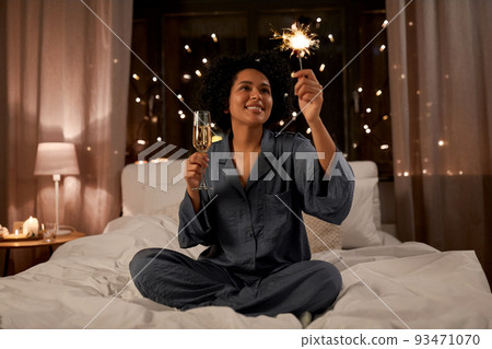 happy woman drinking champagne in bed at night happy woman drinking champagne in bed at night 93471070