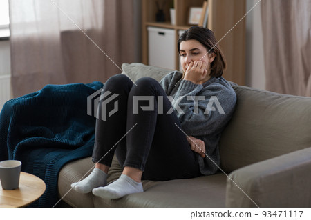 stressed woman sitting on sofa at home stressed woman sitting on sofa at home 93471117