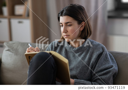 crying woman with diary sitting on sofa at home crying woman with diary sitting on sofa at home 93471119