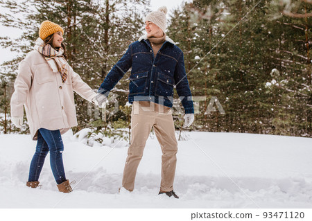 happy smiling couple walking in winter forest happy smiling couple walking in winter forest 93471120