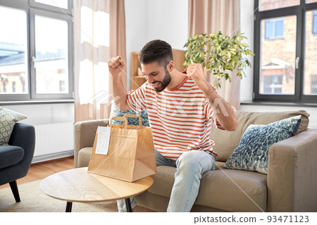 smiling man unpacking takeaway food at home smiling man unpacking takeaway food at home 93471123