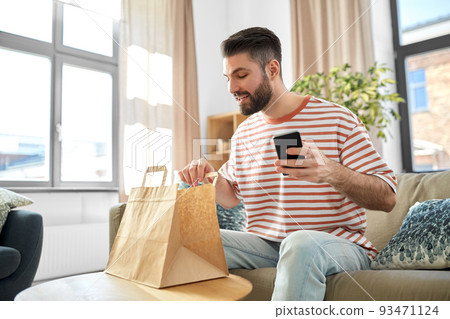 man with phone checking food order at home man with phone checking food order at home 93471124