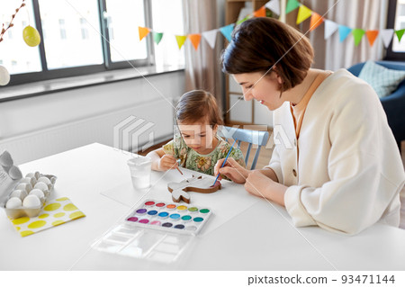 mother with child coloring easter bunny at home 93471144