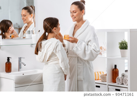 mother and daughter with moisturizer at bathroom 93471161