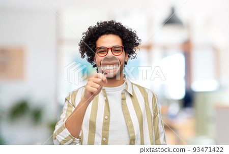 man showing his teeth through magnifying glass man showing his teeth through magnifying glass 93471422