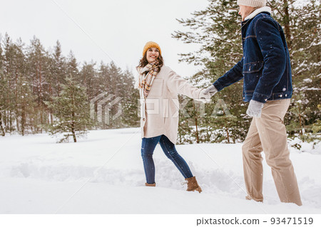 happy smiling couple walking in winter forest happy smiling couple walking in winter forest 93471519