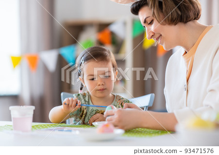 mother with child coloring easter eggs at home mother with child coloring easter eggs at home 93471576