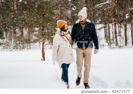 happy smiling couple walking in winter forest happy smiling couple walking in winter forest 93471577