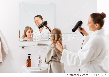 mother and daughter drying hair at bathroom 93471654