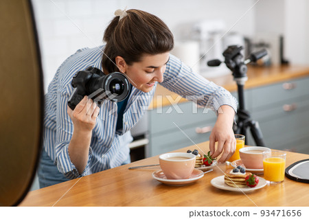 food photographer with camera working in kitchen 93471656