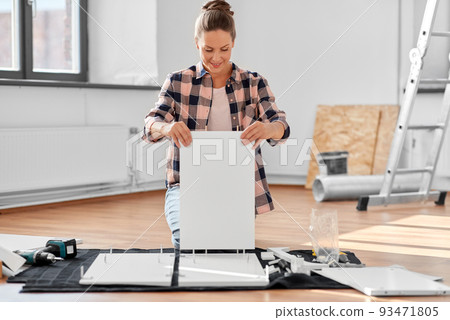 woman assembling furniture at home 93471805