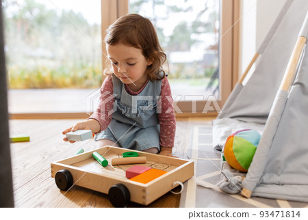 happy baby girl playing with toy blocks at home 93471814