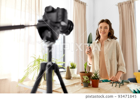 happy woman or blogger planting flowers at home 93471845