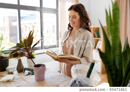 happy woman with book planting pot flowers at home 93471861
