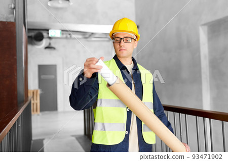 male architect in helmet with blueprint at office male architect in helmet with blueprint at office 93471902