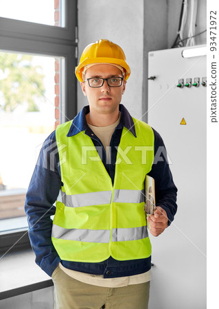 electrician with clipboard at electric board 93471972