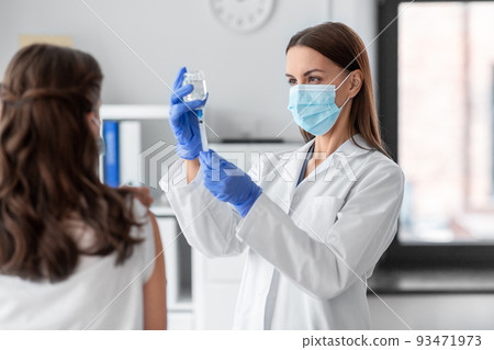 female doctor with syringe vaccinating patient female doctor with syringe vaccinating patient 93471973