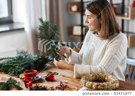 happy woman making fir christmas wreath at home happy woman making fir christmas wreath at home 93471977
