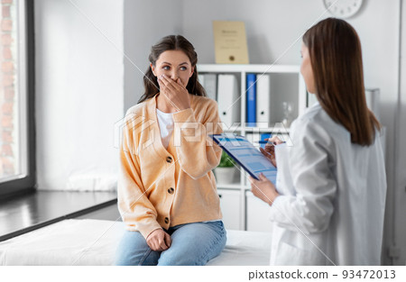 female doctor and coughing woman at hospital 93472013