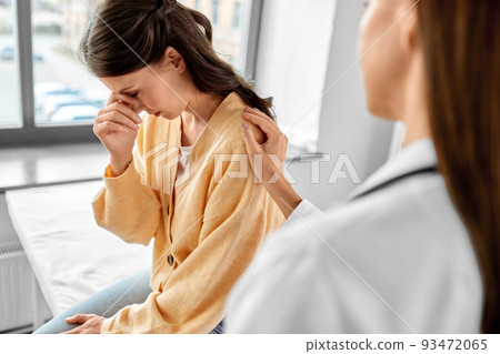 female doctor comforting sad woman at hospital 93472065