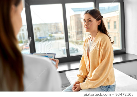 doctor with clipboard and woman at hospital 93472103