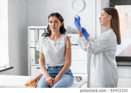 female doctor with syringe vaccinating patient 93472105