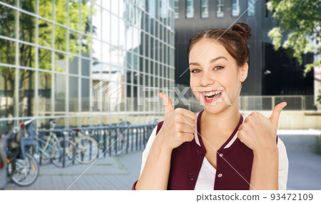 happy teenage girl showing thumbs up in city happy teenage girl showing thumbs up in city 93472109