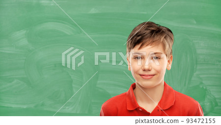 happy student boy over green chalkboard 93472155