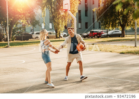 happy couple with ball on basketball playground happy couple with ball on basketball playground 93472196
