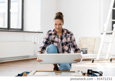 woman assembling new furniture at home woman assembling new furniture at home 93472252