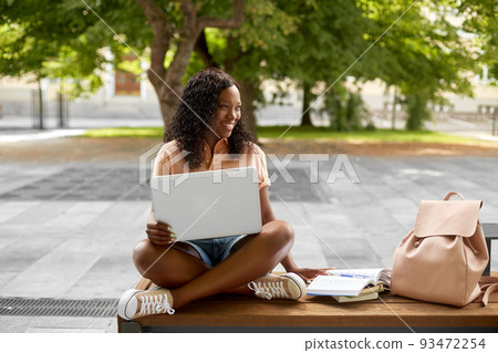african student girl with laptop and books in city african student girl with laptop and books in city 93472254