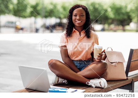 african student girl with coffee, laptop and books african student girl with coffee, laptop and books 93472258