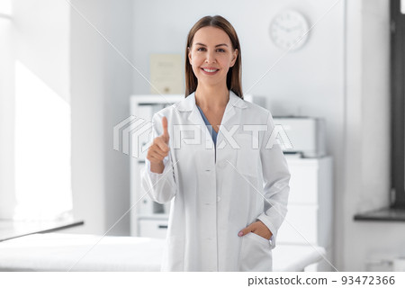 happy female doctor showing thumbs up at hospital happy female doctor showing thumbs up at hospital 93472366
