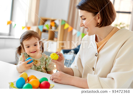 baby girl and mother tapping easter eggs at home baby girl and mother tapping easter eggs at home 93472368