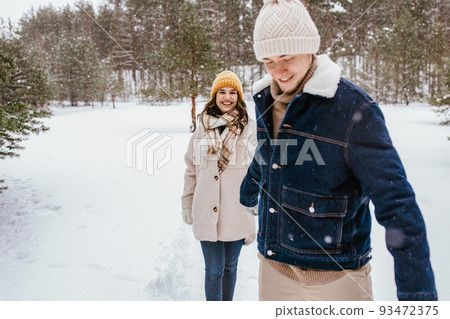 happy smiling couple walking in winter forest happy smiling couple walking in winter forest 93472375